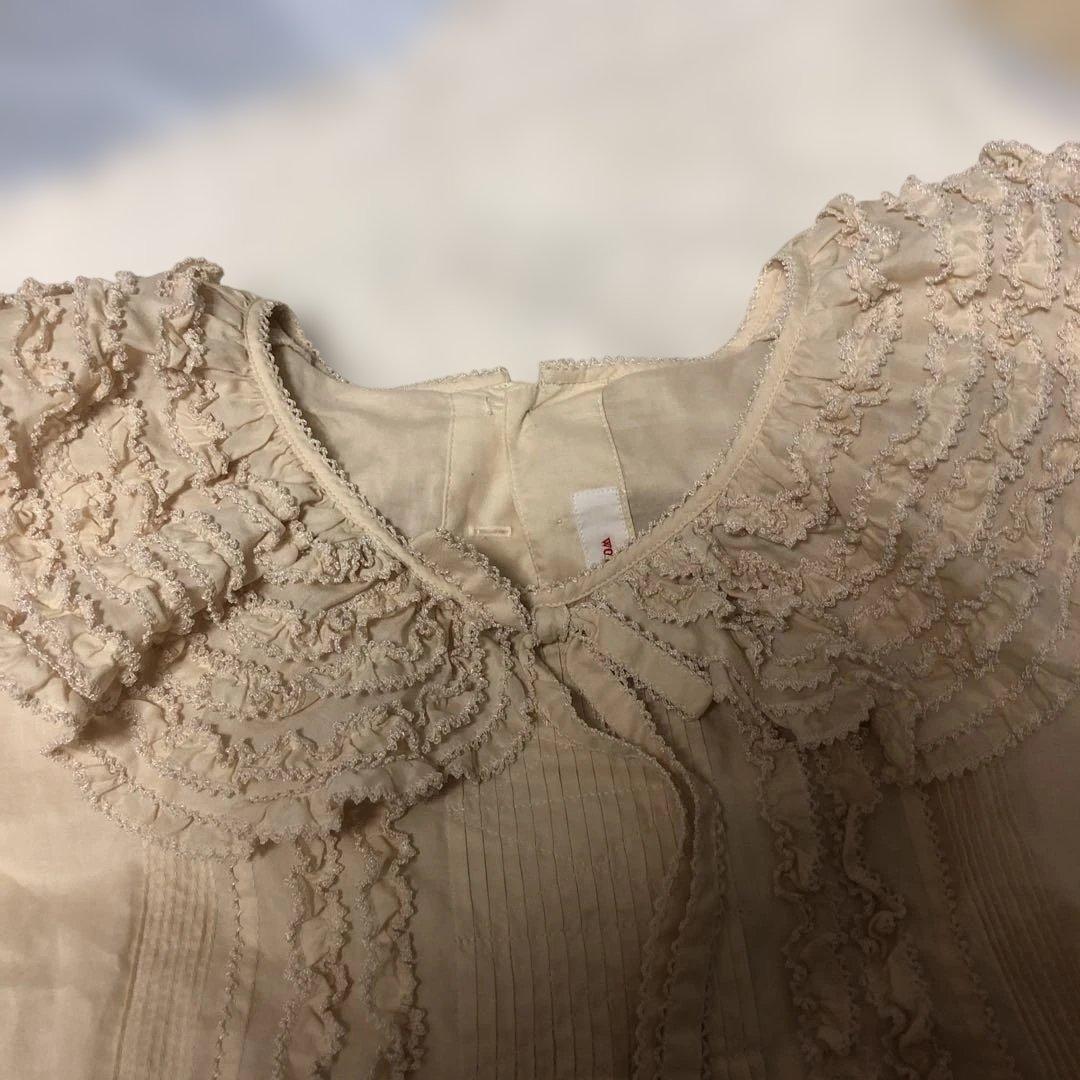 フリル襟のクリーム色ブラウス