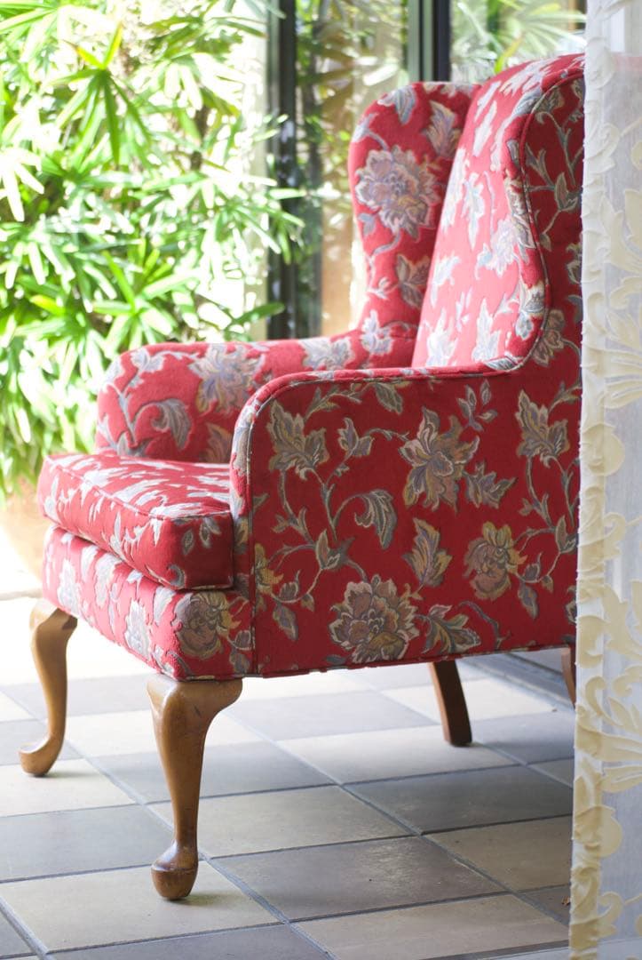 赤い花柄のクラシカルなウィングバックチェア。存在感がありインテリアのアクセントに