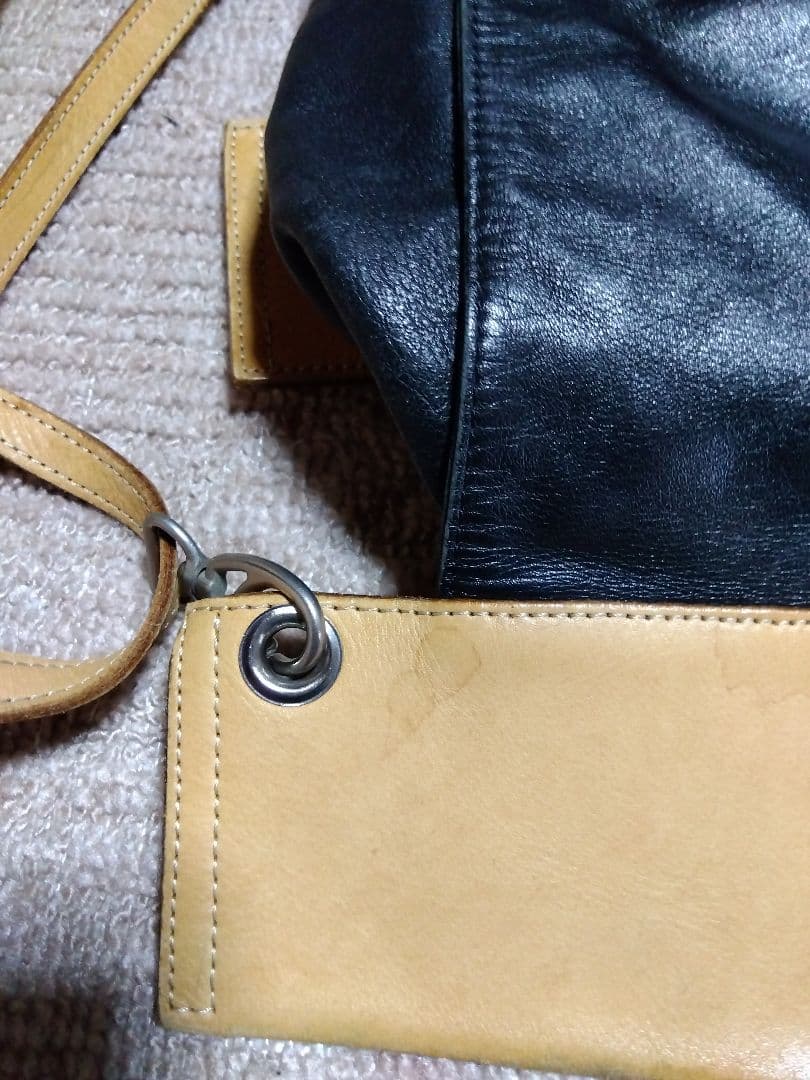 レザー製リュック 黒と黄 Mのロゴ