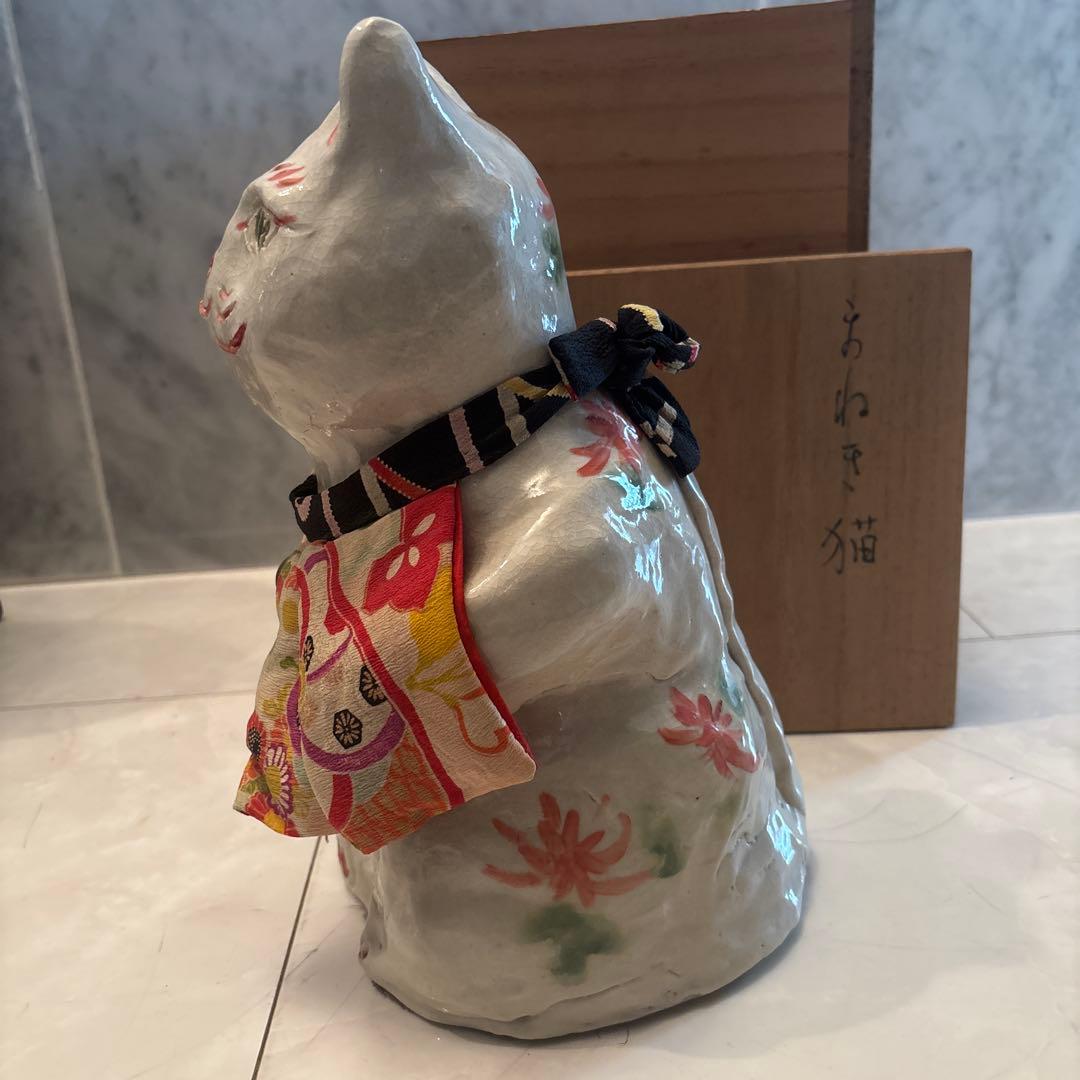 作家さんによる大きな瞳でにっこりと笑う着物の前掛けも美しい招き猫