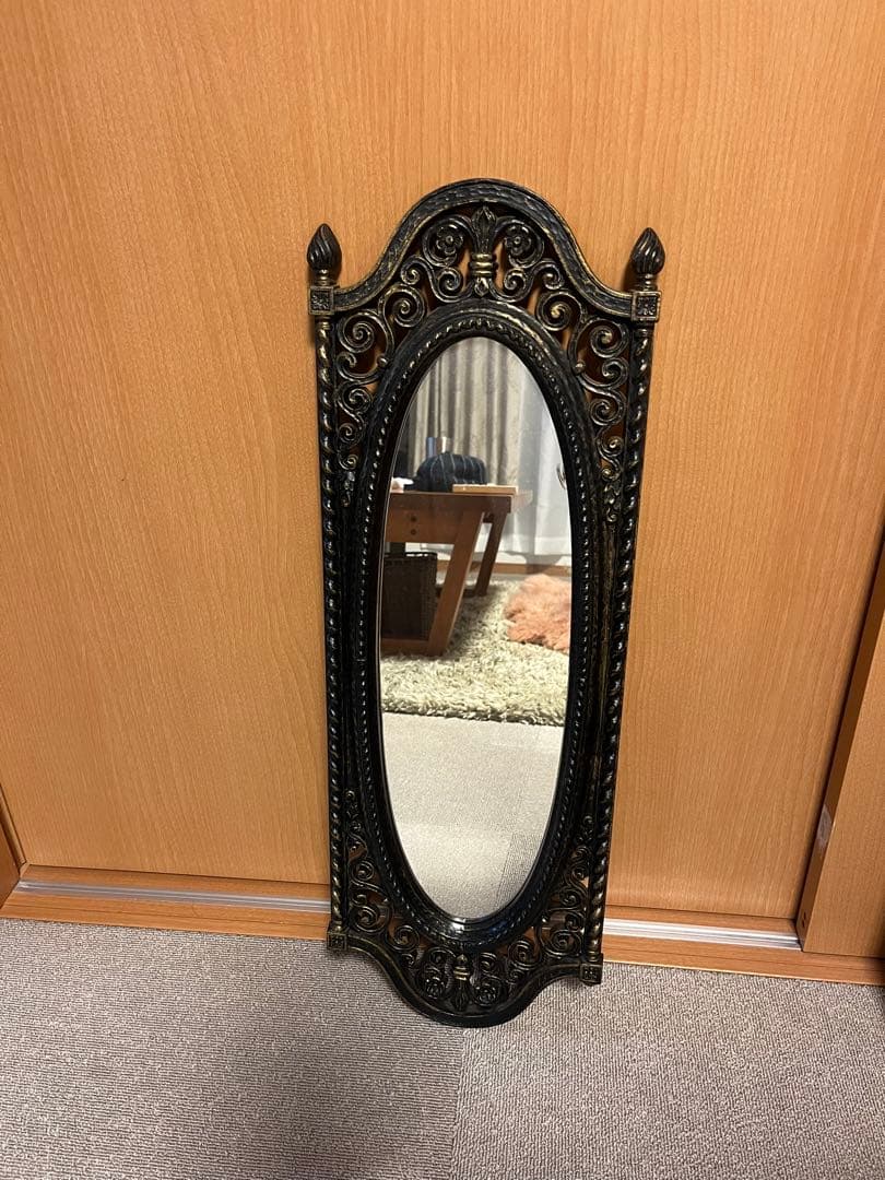 装飾的なオーバル型壁掛け鏡 黒と金のフレーム