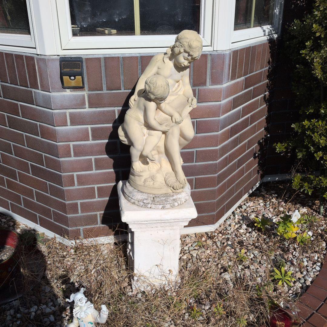 子供と本を読む少女の彫刻